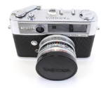 Manual Yashica camera, black and silver body, lens facing forward with lens cap on