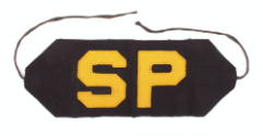 Navy blue rectangular arm band with strings on each tapered end, gold letters "SP" in center