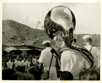 Black and white photograph of a naval band playing in the Philippines with their backs to the c…