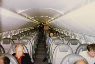 Color image of the seating area on a Concorde airplane, grey seats in pairs of two are on eithe…