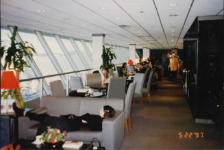 Color image of a seating area in the British Airways Concorde boarding lounge with people seate…