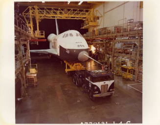 Color photograph of Enterprise being backed out of assembly facility