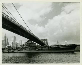 Black and white photograph of USS Intrepid going under the Brooklyn Bridge
