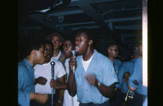 Digitized colored slide of four sailors, wearing dungareers, singing into microphones