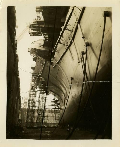 Black and white photograph looking down the port side of USS Intrepid in dry dock