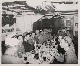 Printed black and white photograph of Jewish crew members during a Passover Seder on board USS …