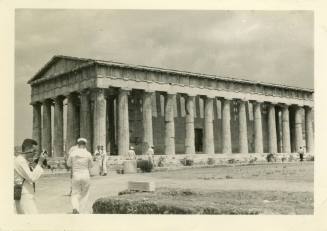 Black and white photograph of a ruined temple in Greece with enlisted sailors walking toward it
