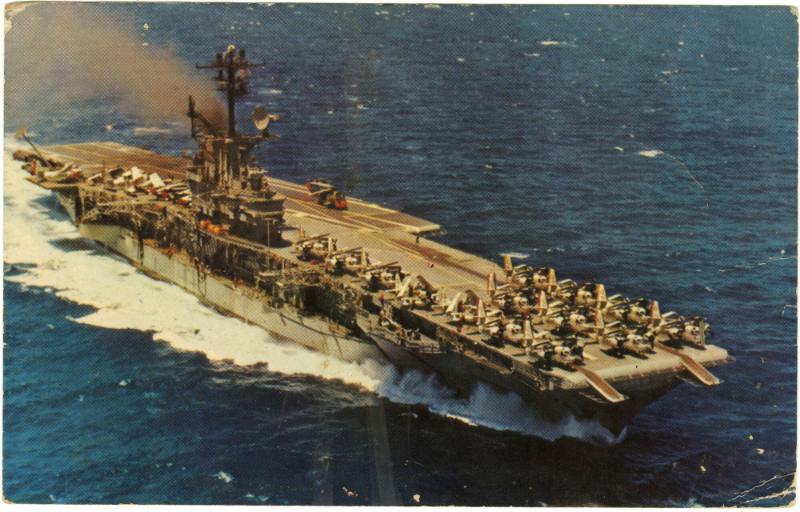 Color postcard of the aircraft carrier USS Intrepid at sea, with airplanes on the flight deck