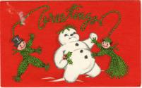 Printed card that reads "Greetings" with a snowman and two dolls made of green string