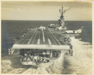 Black and white photograph of USS Intrepid at sea with aircraft visible on the flight deck