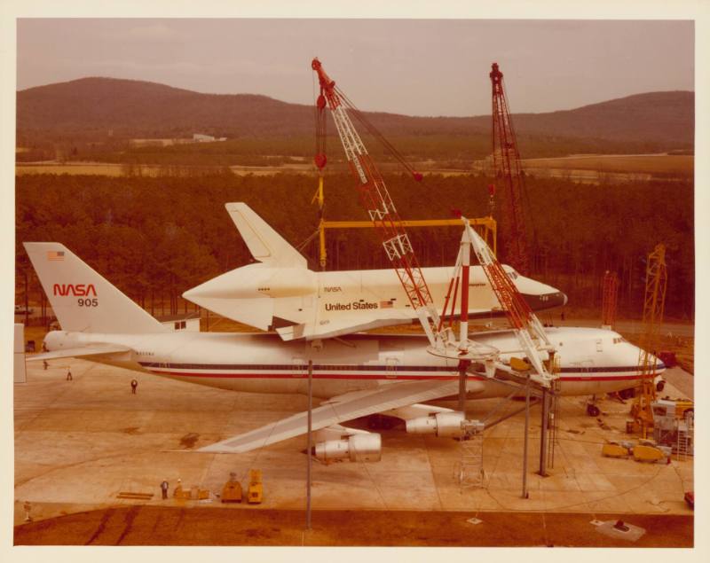 Color photograph of Enterprise being lifted off airplane