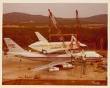 Color photograph of Enterprise being lifted off airplane