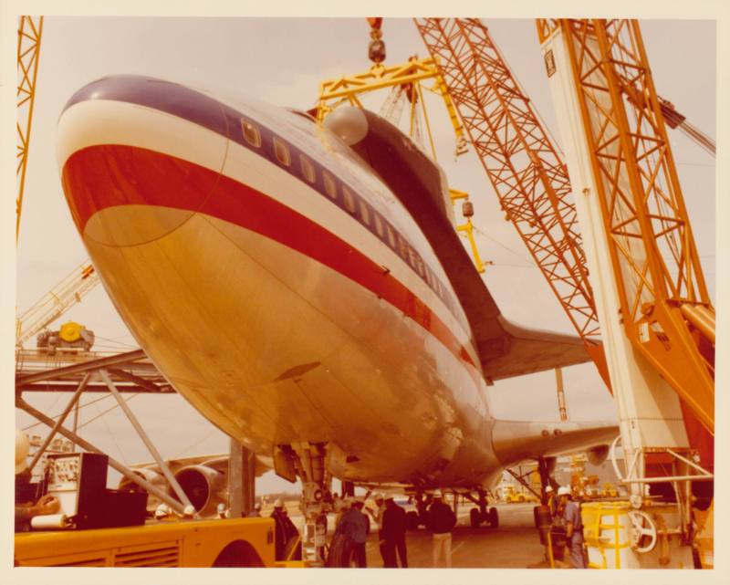 Color photograph of Enterprise on top of a plane from below