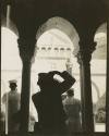 Black and white photograph of a silhouette of a sailor taking a photograph of the exterior of t…