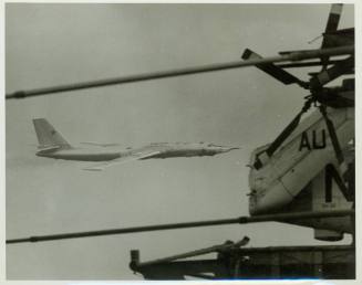 Black and white photograph of a Russian aircraft flying past Intrepid