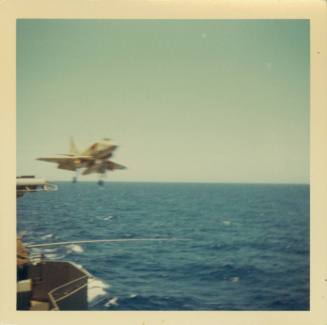 Color photograph of aircraft flying off flight deck