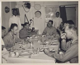 Black and white photograph of Admiral Thomas Sprague at a wardroom table dining with other offi…