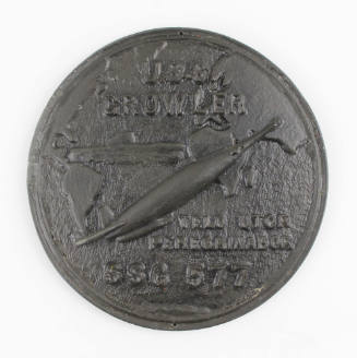 Circular unpainted plaque of USS Growler insignia in relief, Growler is positioned in the Atlan…