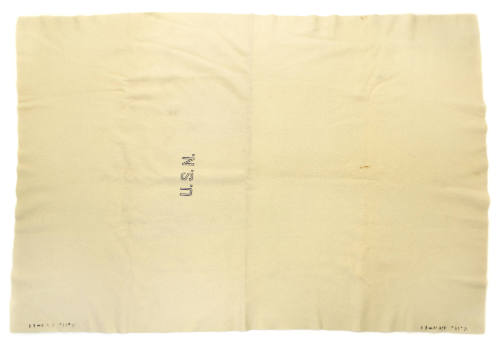 Light colored blanket with U.S.N. stamped in block lettering at center