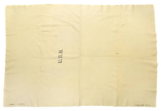 Light colored blanket with U.S.N. stamped in block lettering at center