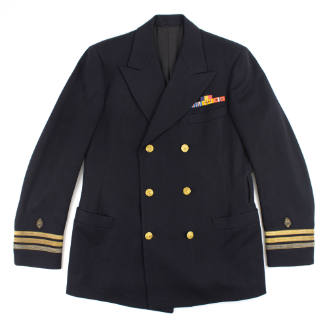 Front of U.S. Navy blue officer's coat with gold buttons, ribbon bars and three gold stripes wi…