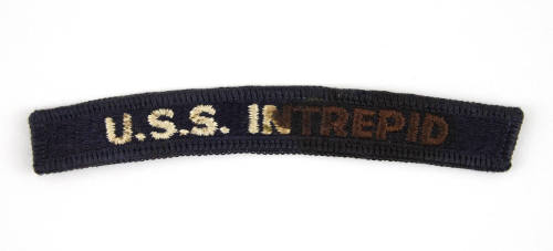 Dark blue U.S. Navy shoulder patch with "USS Intrepid" sewn in white, some letters are stained …