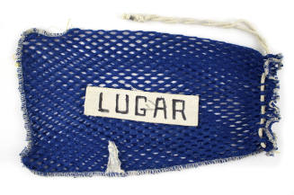 Mesh laundry bag with drawstring, label sewn in center with “Lugar” written in block letters 