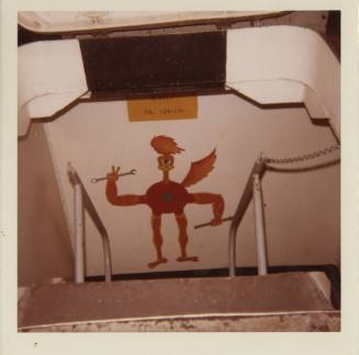 Color photograph of a roadrunner bird painted on a wall at the bottom of a ladder on board the …