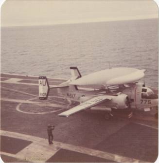 Color photograph of a Grumman E-1 Tracer that has just landed on the flight deck of USS Intrepi…