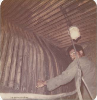 Color photograph of a man inside one of USS Intrepid's boilers