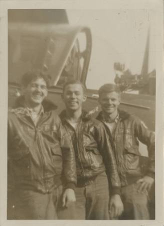 Photograph of three men standing in front of a Curtiss SB2C Helldiver.