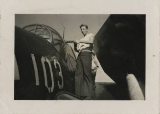 Black and white photograph of a man standing on the left wing of a TBM-3 Avenger.
