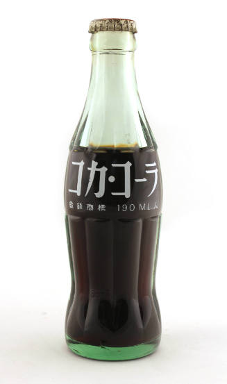 Unopened glass Coca-Cola bottle with white Japanese characters printed on bottle and brown soda…