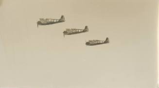 Black and white photograph of three F6F Hellcat fighter planes in flight