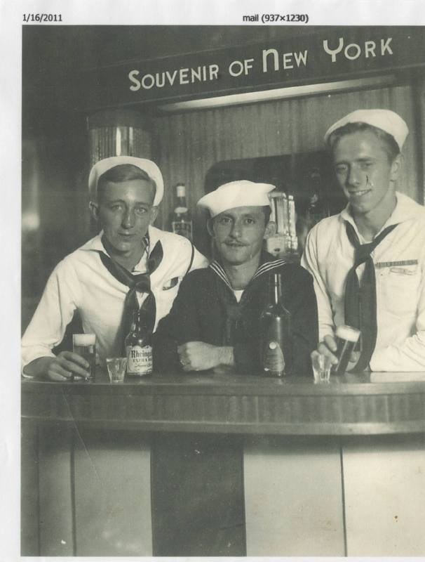 Black and white photograph of three sailors standing at a  bar, with a sign saying "Souvenir of…