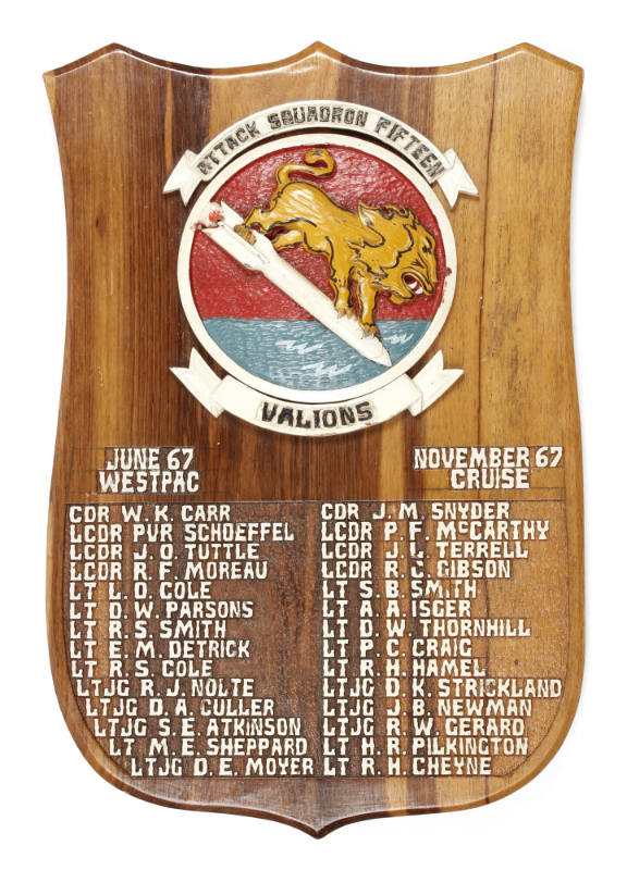 Wood plaque with circular colored VA-15 insignia depicting a lion riding a rocket, banners read…