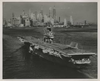 Black and white photograph of USS Intrepid sailing in New York harbor, lower Manhattan skyline …