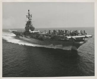 Black and white photograph of aircraft carrier USS Intrepid at sea with airplanes parked on for…