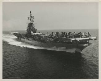 Black and white photograph of aircraft carrier USS Intrepid at sea with airplanes parked on the…