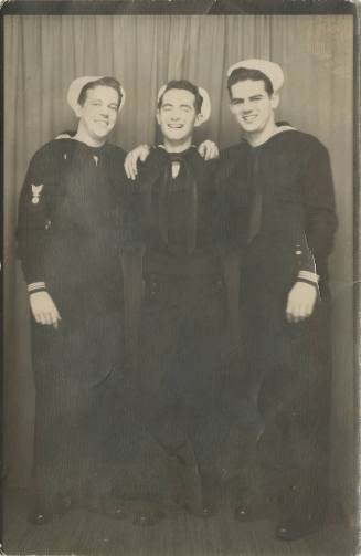 Black and white photograph of three smiling sailors in dress blue uniforms