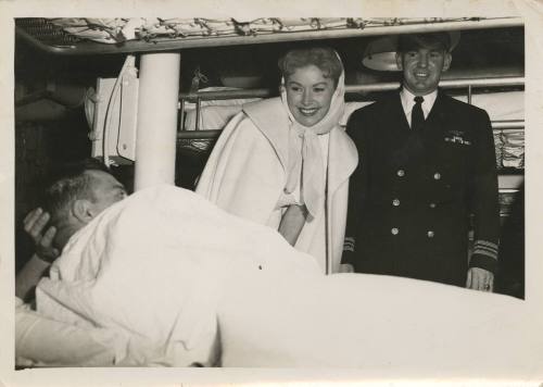 Black and white photograph of actress Rhonda Fleming visiting USS Intrepid's sick bay