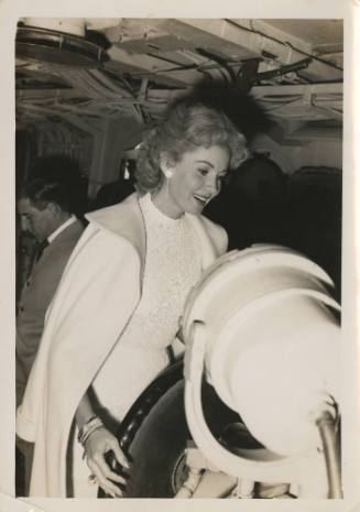 Black and white photograph of the actress Rhonda Fleming at USS Intrepid's helm