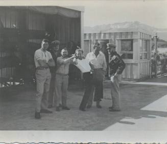 Black and white photograph of four men standing on a street at the Navy facility in Adak, Alask…