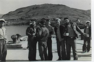 Black and white photograph of sailors in dungarees on a pier in Adak, Alaska