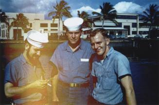 Color photograph of three sailors in dungarees at Pearl Harbor, Hawaii