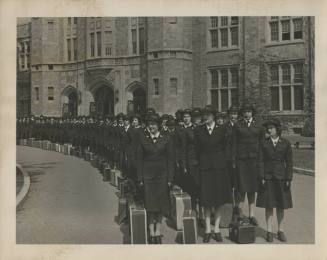 Black and white photograph of WAVES recruits in uniform with suitcases at their feet standing o…