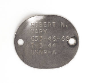 Circular metal military dog tag with holes on each side, engraved inscription “Robert N. Mary 6…