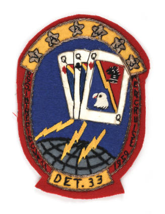 Embroidered patch with an image of three queen cards and yellow lightning bolts, around the red…