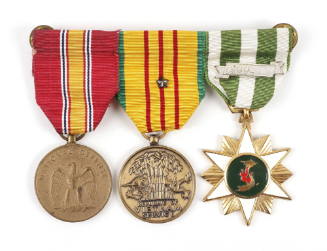 Image of three service medals attached to one ribbon bar, ribbons have various colors, medals a…