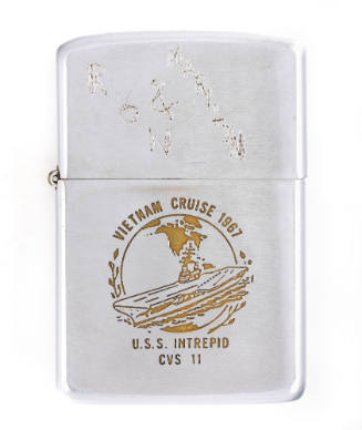 Silver lighter with engraved image of aircraft carrier at sea in front of globe on base, inscri…